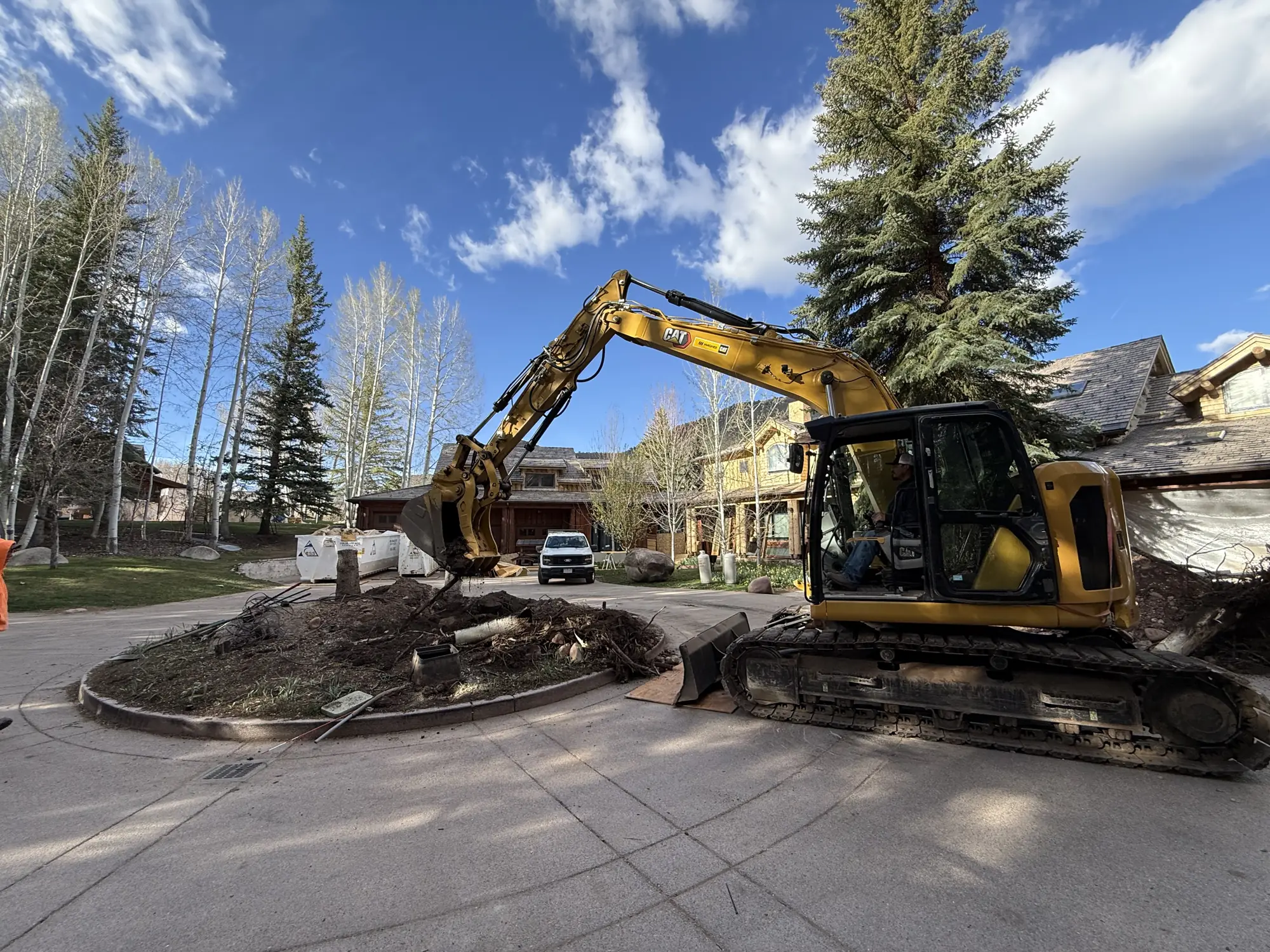 Ridgeline excavator removing a driveway island at a mountain residence
